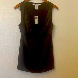 Max Studio no sleeve slinky, black top with a heavy trim around the V neckline.